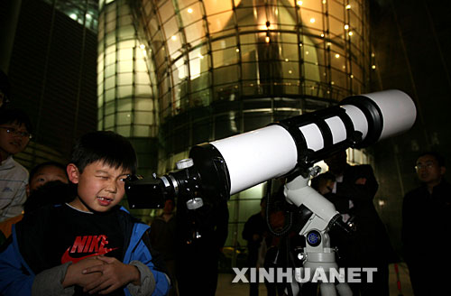 10月24日，一名兒童在北京天文館用天文望遠鏡觀賞月亮。 當日，搭載著我國首顆探月衛星嫦娥一號的長征三號甲運載火箭在西昌衛星發射中心三號塔架點火發射。連日來，北京天文館免費開放天文館和觀測儀器，吸引眾多市民前來觀月。 新華社記者李明放攝 